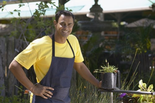 A gardener inspecting tools and site conditions for safety